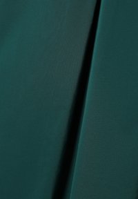 Tahke smaragdhrohelise kangaga, millel on sile tekstuur, peene läikega ja korrapäraste sirgete voltidega. Sobib erinevate rõivaste disainide jaoks.