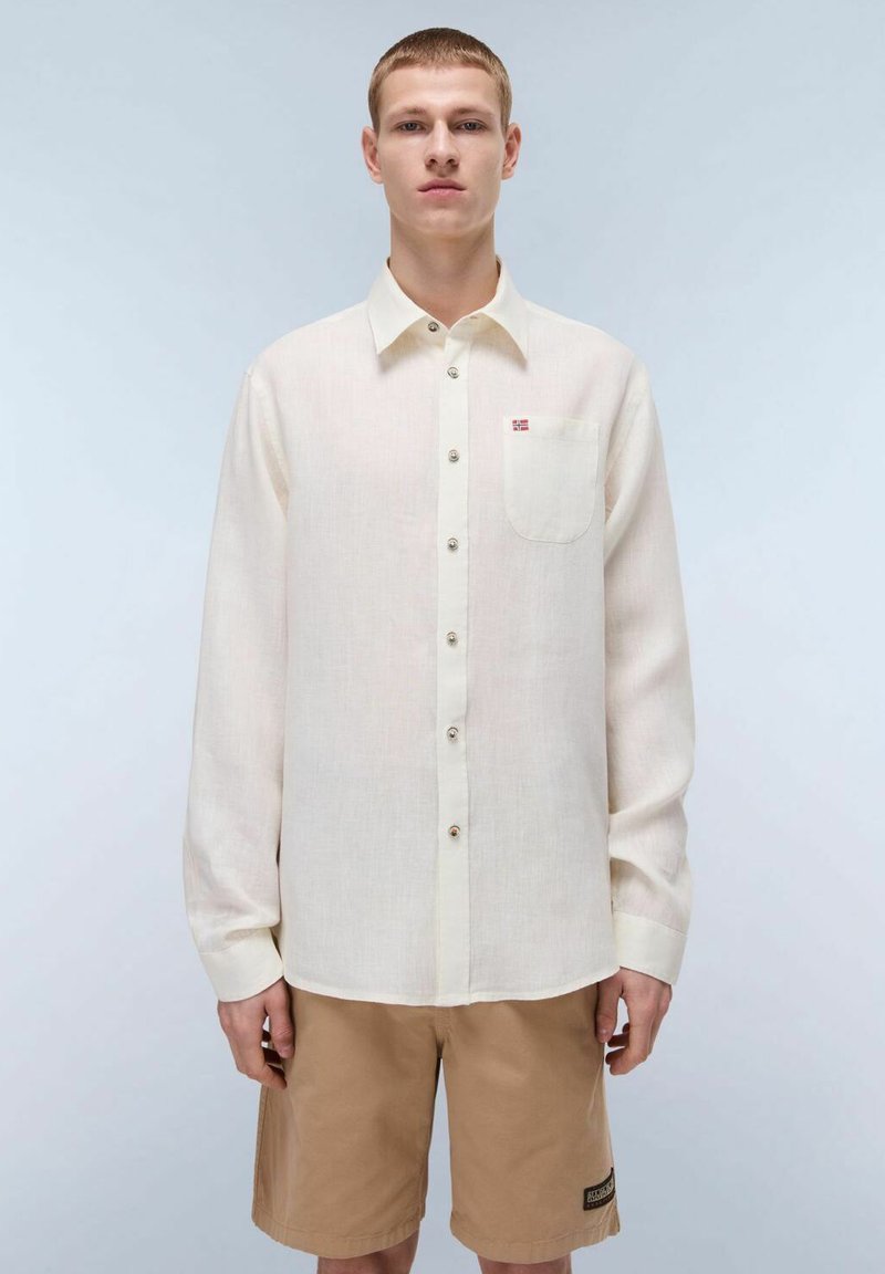 Camicia a maniche lunghe color beige chiaro, realizzata in lino, con un abbottonatura sul davanti, una tasca sul petto e un piccolo dettaglio a bandiera sulla tasca.