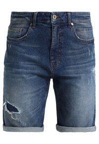 Mäns blå denimshorts med uppvikta fållar och en sliten reva vid vänster lårficka.
