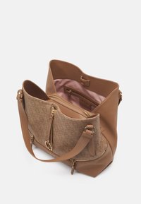 Brun skuldertaske med en struktureret overflade, glatte accenter, lynlåslomme, canvasforing og dobbelte skulderremme.