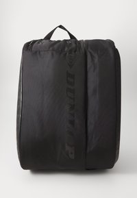 Dunlop schwarze Sporttasche aus strukturiertem Stoff, mit einem oberen Griff, einem glatten Reißverschluss und einem auffälligen Logo auf der Vorderseite bedruckt.