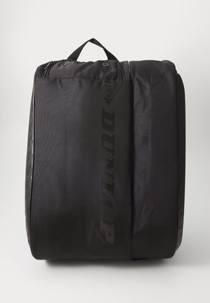 Dunlop juodos spalvos sportinė kuprinė, pagaminta iš tekstūruoto audinio, savybių turinti viršutinę rankeną, sklandų užtrauktuką ir ryškiai atspausdintą logotipą priekyje.