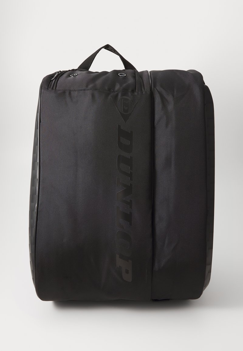 Dunlop schwarze Sporttasche aus strukturiertem Stoff, mit einem oberen Griff, einem glatten Reißverschluss und einem auffälligen Logo auf der Vorderseite bedruckt.