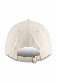 Gorra de béisbol beige con un acabado de tela suave, visera curva y correa ajustable en la parte posterior, que cuenta con ojales de ventilación en los lados.