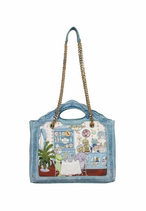 Sac à main bleu avec poignées en chaîne dorée, présentant une scène illustrée d'un salon de thé vintage avec deux femmes assises, un chat derrière le comptoir et une plante en pot.
