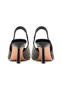 Tacon alto tipo slingback en color negro, con una superficie texturizada y adornos plateados, y la parte inferior lisa en negro.