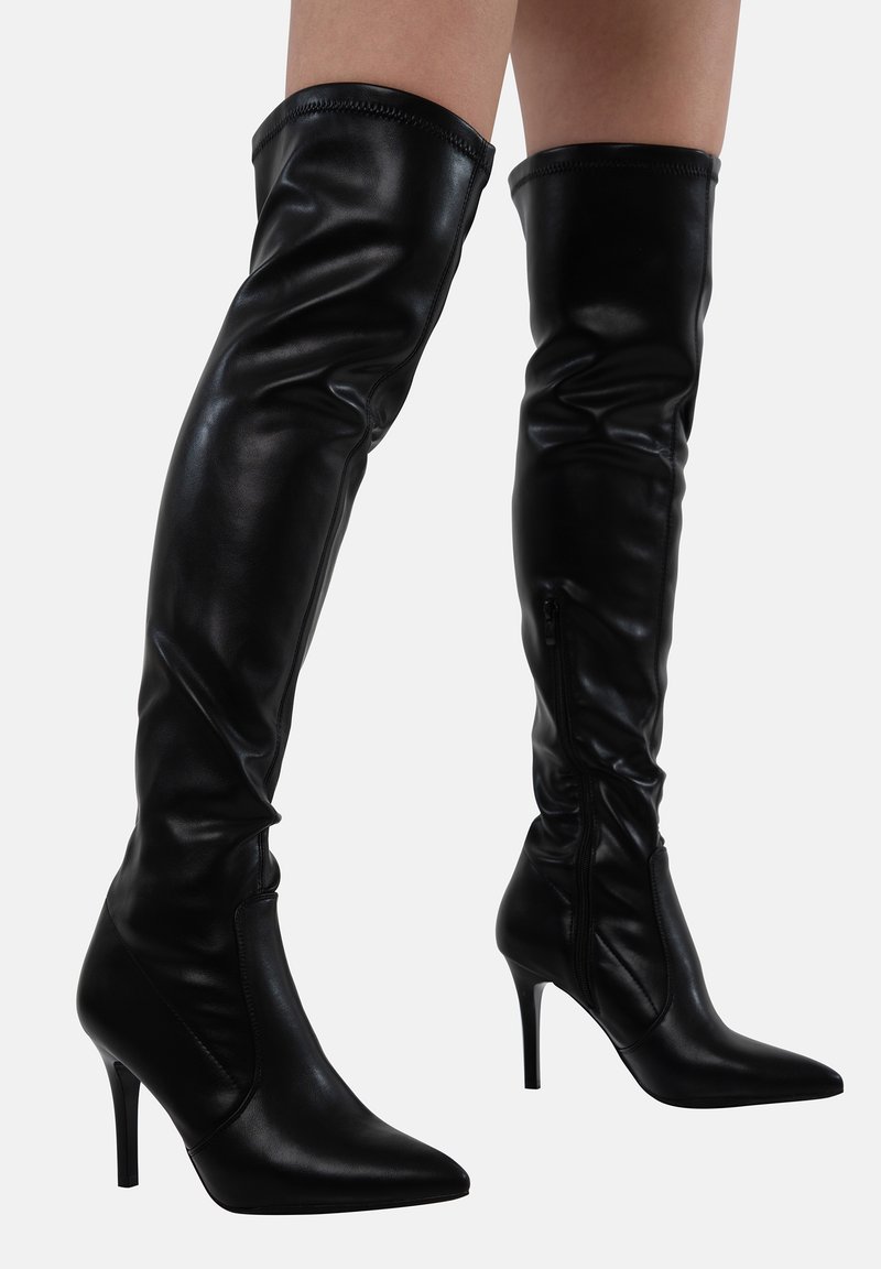 Botas de muslo de cuero negro con un diseño elegante, punta afilada y tacones de aguja. Presentan una cremallera lateral para un fácil calzado.