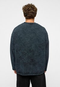 Overmaat grijze sweatshirt, gemaakt van katoen, met ronde hals, lange mouwen, een gestructureerd oppervlak met een licht vervaagde uitstraling.