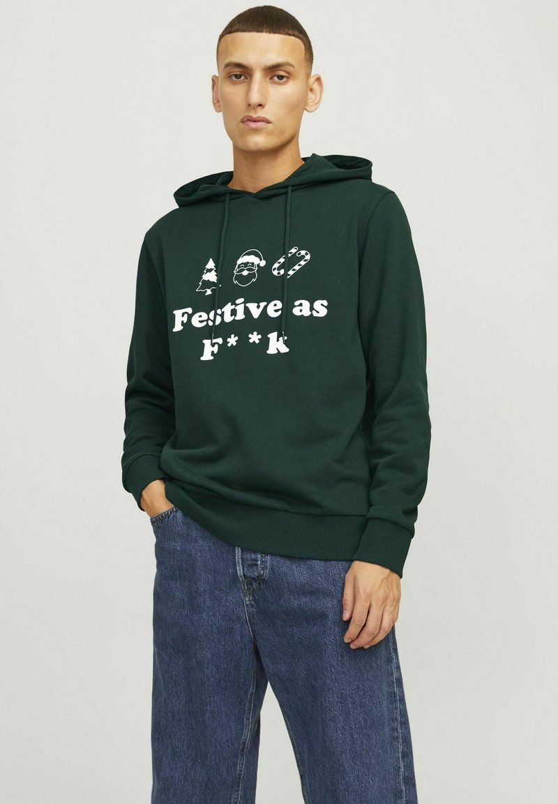Felpa verde scuro con una grafica anteriore che raffigura un albero, Babbo Natale e una canna di zucchero, insieme al testo "Festivo come F***". Tessuto morbido, vestibilità casual.