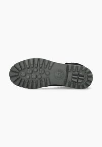 Semelle extérieure en caoutchouc noir avec des rainures profondes et des motifs circulaires ; présente un logo et un texte détaillant. Durable et conçu pour l'adhérence.