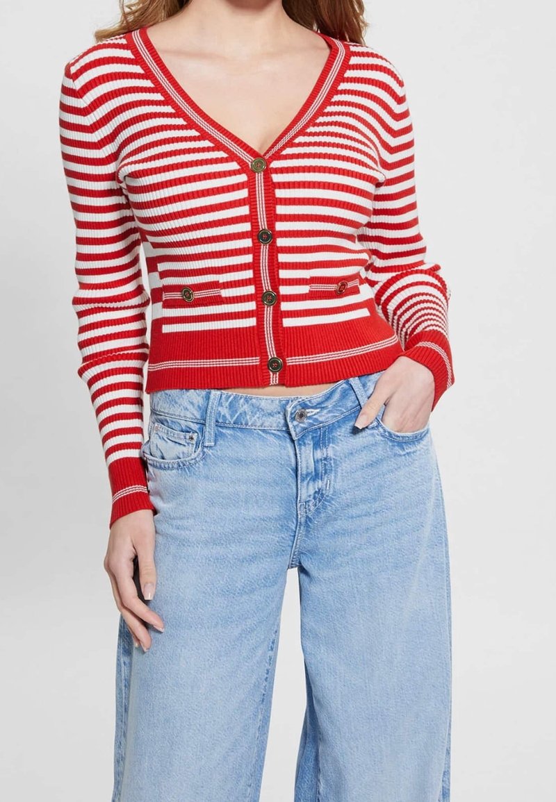 Cardigan rayé rouge et blanc avec un col en V, fermeture à boutons, texture côtelée et deux poches avant, associé à un jean bleu clair.