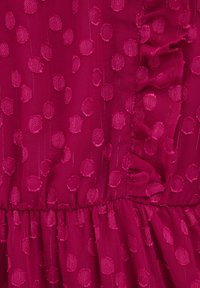 Magenta tkanina s teksturiranimi pikami, vertikalnimi črtami, nabranim pasom in nabrano šivno podrobnostjo na desni strani.