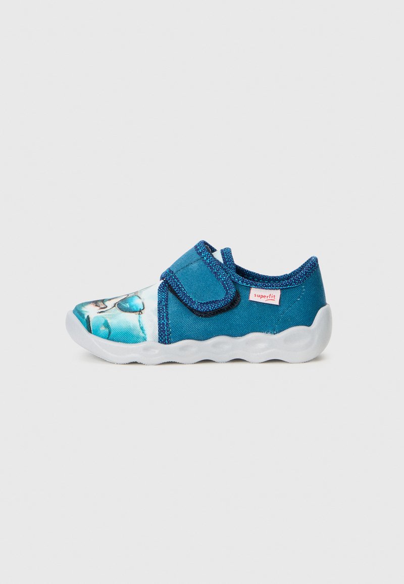 Blaue Stoffschuhe mit einem bedruckten Design an der Spitze, Klettverschluss und einer strukturierten weißen Gummisohle mit welligem Rand.