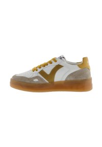 Sneaker bianco con una punta in suede color marrone chiaro, dettagli gialli e una suola gommosa traslucida. Design con lacci e dettagli perforati.