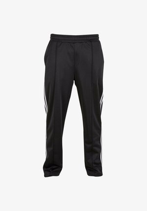Černé sportovní kalhoty vyrobené z hladkého syntetického materiálu. Mezi vlastnosti patří stahovací pas a tři bílé boční pruhy.