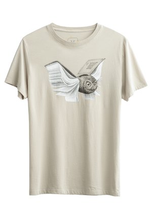Beige katoenen t-shirt met een grafische afbeelding van een vliegende uil met open boekvleugels, gedetailleerd in zwart-wit met expressieve ogen.