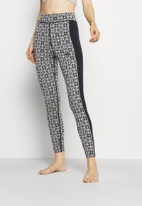 Tights med ett mönstrat tyg som har ett diamant- och snöflingemönster i vitt och marinblått, med en enfärgad marinblå sidopanel och hög midja.
