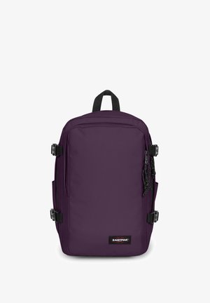 Purppuranvärinen suorakulmainen Eastpak-reppu, jossa yläkahva, etutaskun vetoketju ja sivusaumojen soljet valkoisella taustalla.