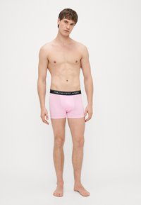 Ružové bavlnené boxerky s kontrastným čiernym pásikom, na ktorom je logo "POLO RALPH LAUREN". Mäkká textúra a priliehavý dizajn.