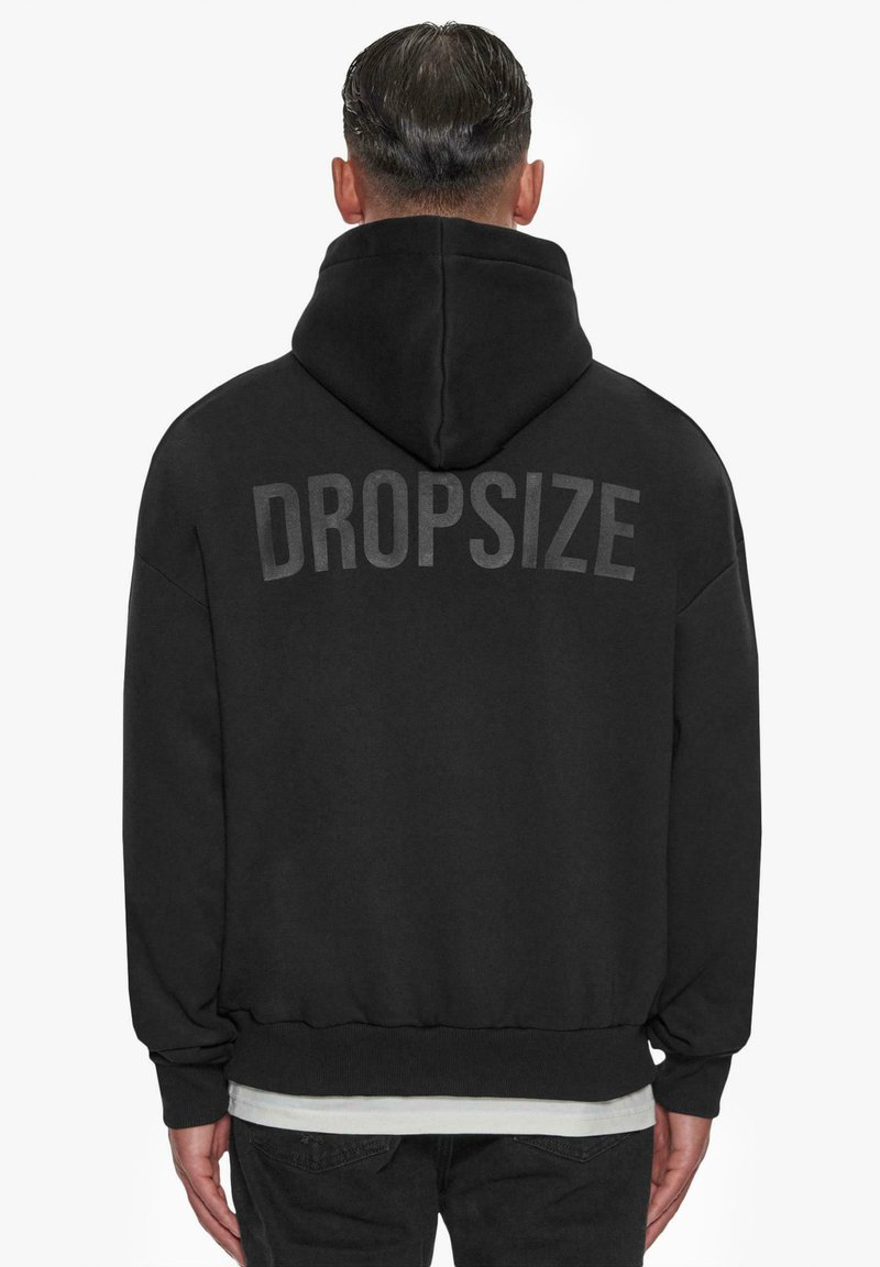 Schwarze Kapuzenjacke mit großen grauen "DROPSIZE"-Text auf der Rückseite. Mit Kordelzugkapuze und gerippten Bündchen und Saum. Weicher Stoff.