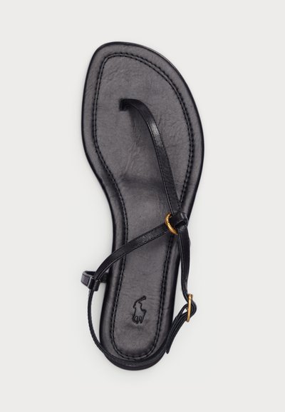 Μαύρο δερμάτινο σανδάλι με επίπεδο πάτο. Διαθέτει λεπτές λωρίδες και χρυσή λεπτομέρεια. Υφασμάτινη εσωτερική σόλα με ορατές ραφές και λογότυπο.