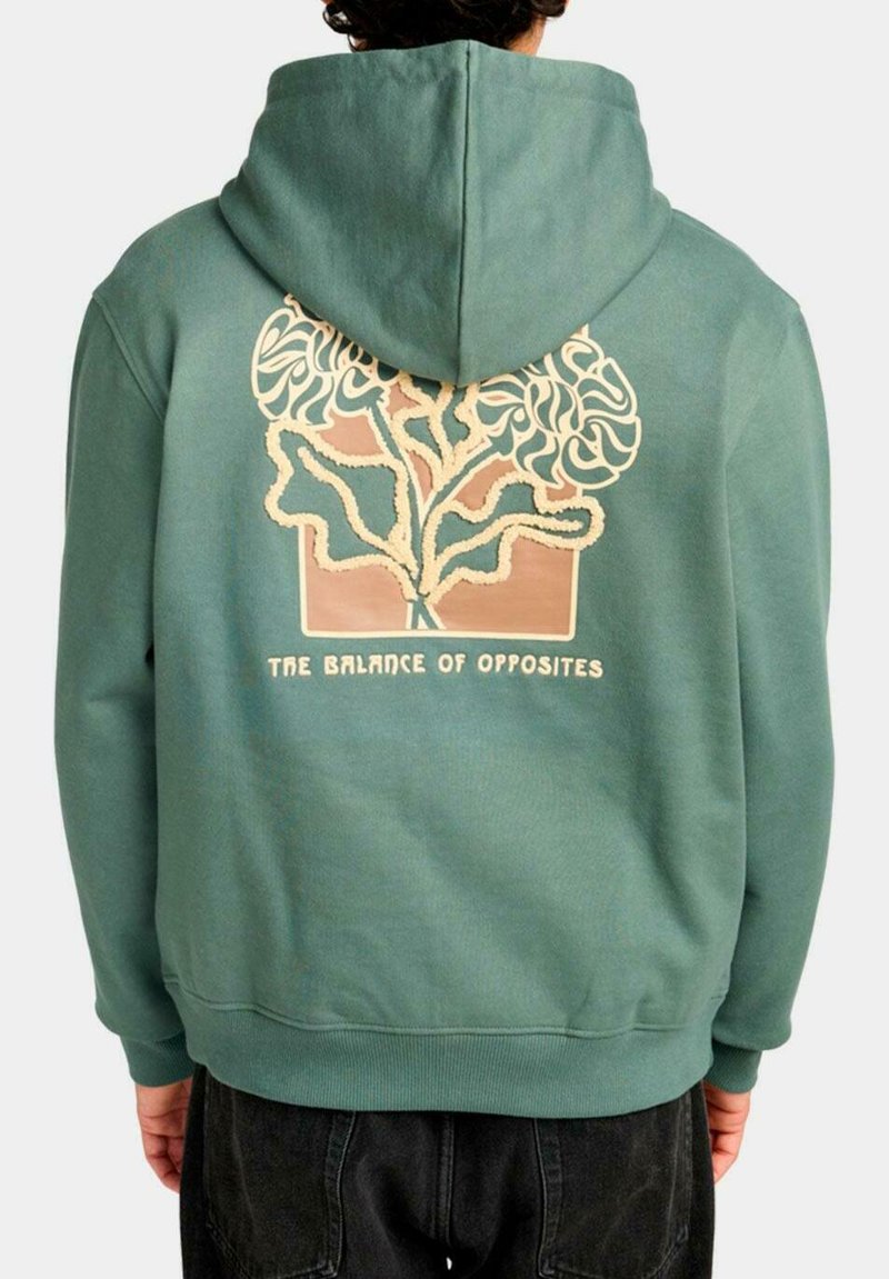 Sudadera verde con un gran gráfico en la parte posterior que presenta un diseño de árbol en crema y marrón, con el texto "EL EQUILIBRIO DE LOS OPUESTOS" debajo.