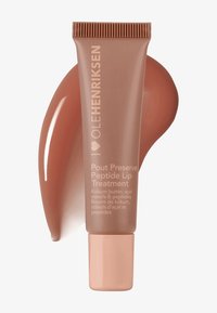 Tube von Ole Henriksen Pout Preserve Peptide Lip Treatment mit braunem Lippenbalsam-Fleck dahinter auf weißem Hintergrund.