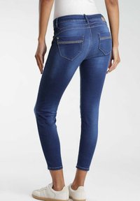 Smala jeans i mörkblå denim med en mjuk textur. Har bakfickor med kontrastsöm och en midja i medelhöjd.