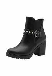 Black ankle boot made of smooth leather with a textured strap adorned with pearls and studs, featuring a chunky block heel and rubber sole.