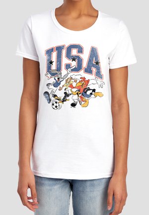 Weißes T-Shirt mit großen "USA" Buchstaben und Cartoonfiguren, die vorne unter dem Text Fußball spielen.