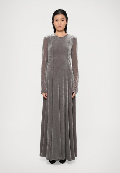 Robe en velours gris long avec un décolleté rond et des manches longues, présentant une jupe évasée et des détails de coutures verticales.