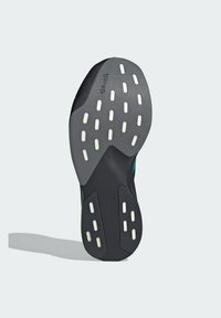 Black athletic shoe sole with white traction patterns, featuring a textured surface and a slight curve at the heel. Brand logo visible.