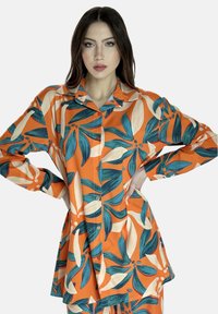 Kleurige langemouwenshirt met een oranje basis en blauwe en crèmekleurige bladdessins, met een knoopsluiting aan de voorkant en een klassiek kraagontwerp.