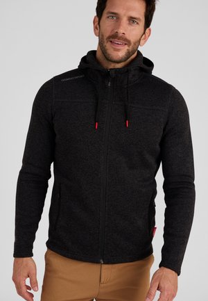 Haut de survêtement zippé noir avec une finition texturée, capuche réglable et tirettes de zip rouges contrastantes. Comprend des poches latérales et un détail logo.