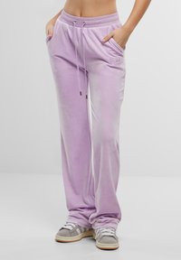 Lila velours joggers met een tailleband met trekkoord, zijzakken en subtiele logo borduring. Ontspannen pasvorm met een gladde textuur.