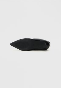 Scarpa con tacco a stiletto nero, punta affusolata e tomaia in pelle liscia. Presenta una suola in gomma testurizzata e minimali dettagli decorativi.
