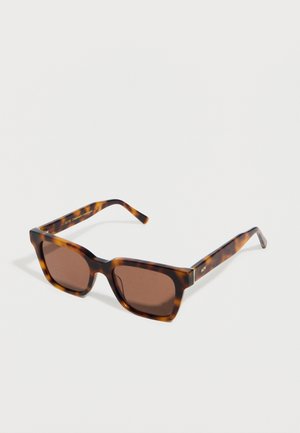 Lunettes de soleil rectangulaires en écaille de tortue avec des verres teintés marron et des branches larges, posées à plat sur une surface blanche.