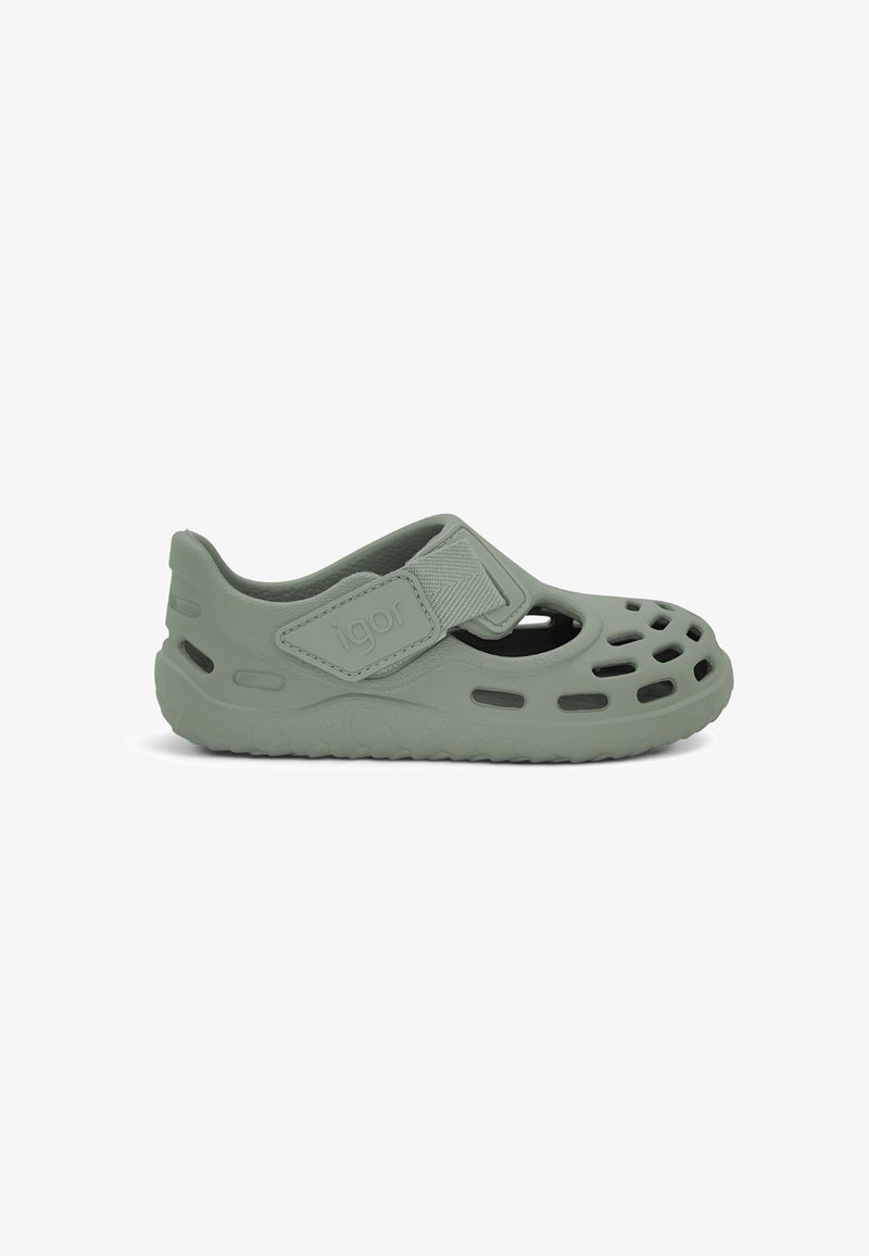 Chaussure décontractée à bout fermé vert clair avec trous de ventilation, bride réglable et semelle plate conçues pour le confort et la respirabilité.
