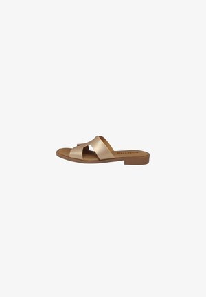 Sandalo beige piatto con ampie fasce traforate e tacco basso, mostrato di profilo su sfondo bianco.