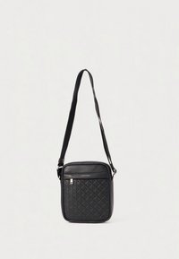 Zwarte schoudertas met een getextureerd, gewatteerd patroon, rechthoekige vorm, ritssluiting aan de bovenkant, verstelbare band en merkdetail aan de voorkant.
