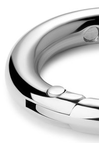 Metal nøglering med poleret kromfinish, cirkulær form, sømløst design, en lille knap og en sprække til montering af genstande.