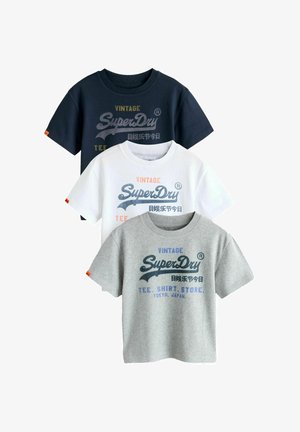 Három póló: tengerészkék, fehér és szürke. Mindegyiken a "SuperDry" logó különböző színekben, rövid ujjúak és klasszikus kerek nyakú kivitelben.