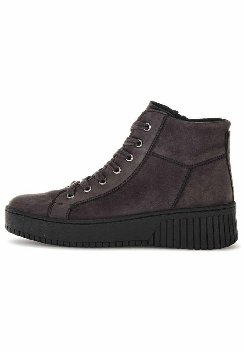 Hochschuh aus dunkelgrauem Wildleder mit einer klobigen schwarzen Gummisohle, ausgestattet mit Metallösen für die Schnürsenkel und vertikalen Rillen auf der Sohle.