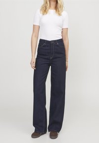 Tmavě modré vysoké pasové široké džíny vyrobené z denimu, s klasickým pětipocket designem a zapínáním na předním knoflíku.