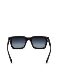 Lunettes de soleil rectangulaires noires avec verres dégradés foncés et montures épaisses à motif écaille sur fond blanc.