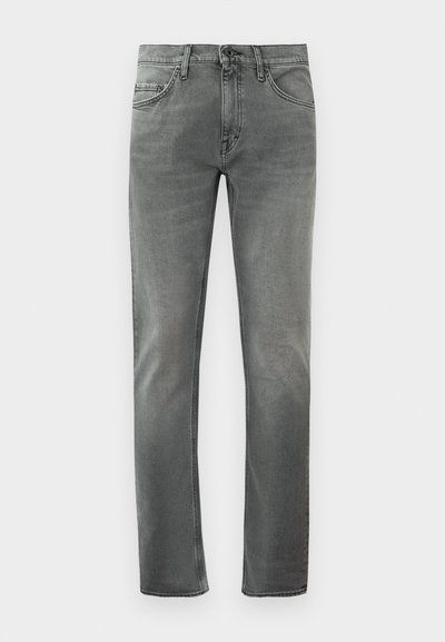 Grå slim-fit jeans med frontlommer og knaplukning, vist mod en hvid baggrund.