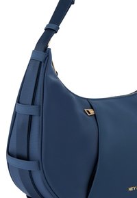 Navyblauwe handtas van glad materiaal, met een gouden accent en een gestructureerd ontwerp, voorzien van een verstelbare schouderband en verticale panelen.