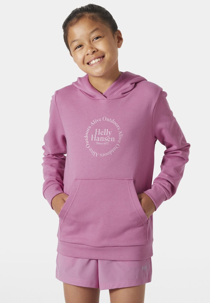 Růžová mikina s kapucí a přední kapsou, bílé logo "Helly Hansen", doplněná odpovídajícími šortkami. Tkanina vypadá měkce a má texturovaný povrch.