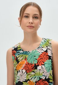 Ärmelloses, florales Oberteil mit schwarzem Hintergrund und lebhaften grünen, orangen und weißen Blattmustern. Glatter Stoff und runder Ausschnitt.