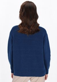 Maglione in maglia di un blu scuro, dalla vestibilità ampia, con una finitura testurizzata, polsini e orlo a coste, e spalle ribassate. Realizzato in un materiale morbido e caldo.